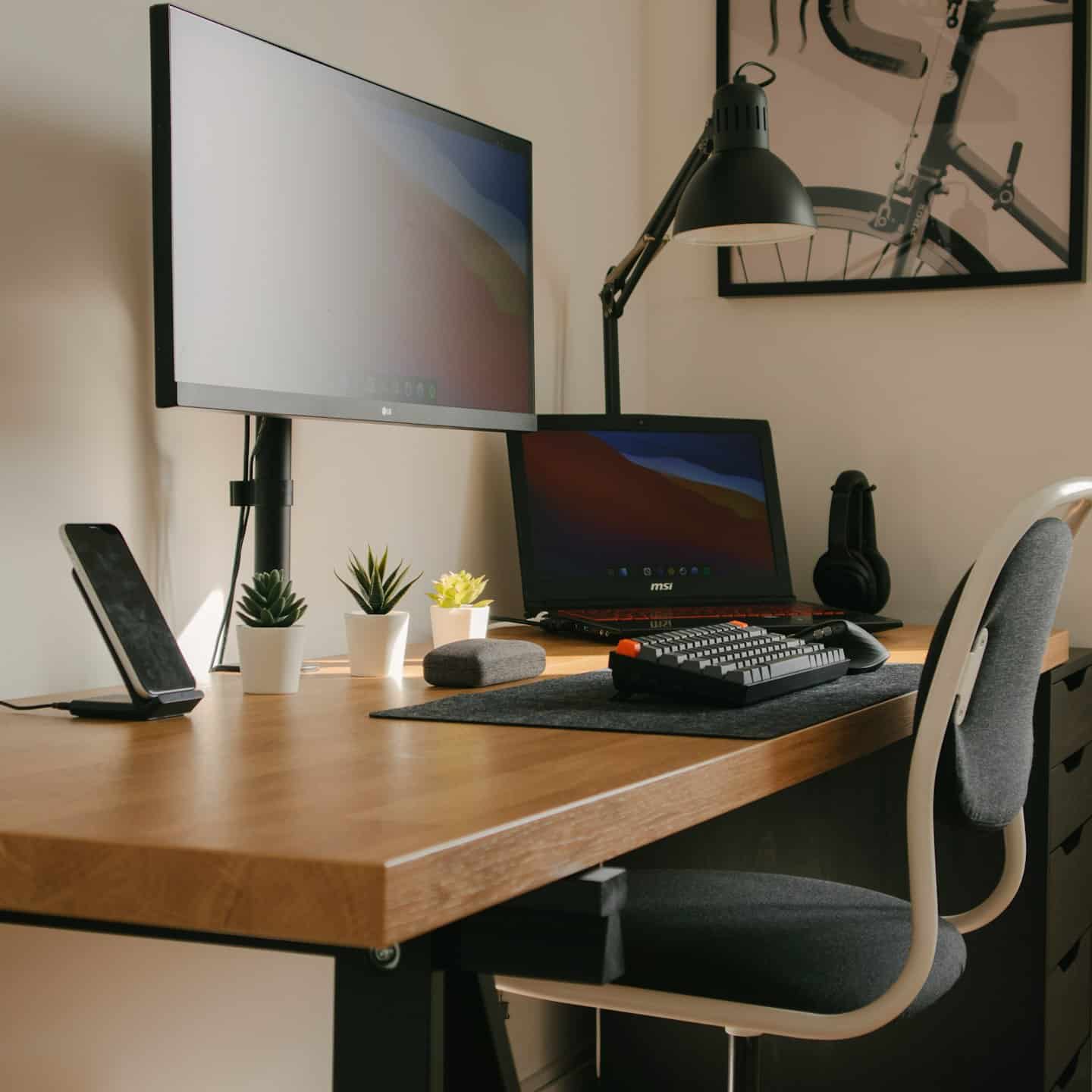 Home office with dual monitors, laptop, and succulents.