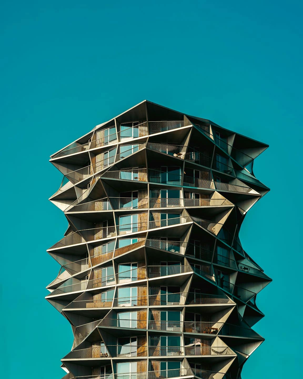 Modern apartment building with geometric balconies and wooden accents.