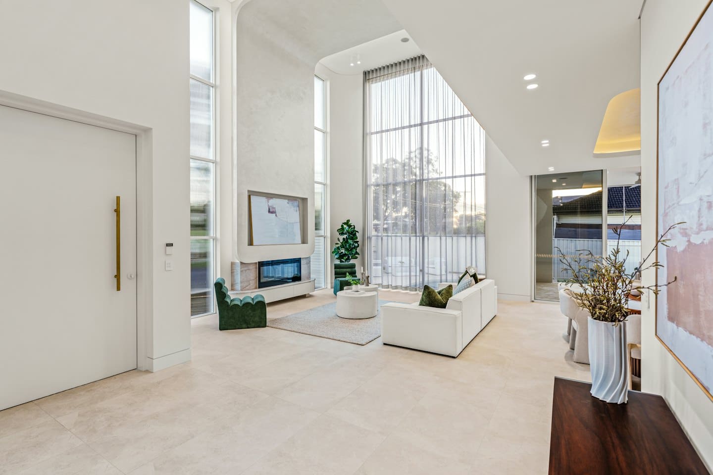 Spacious living room with white sofa and green chairs.